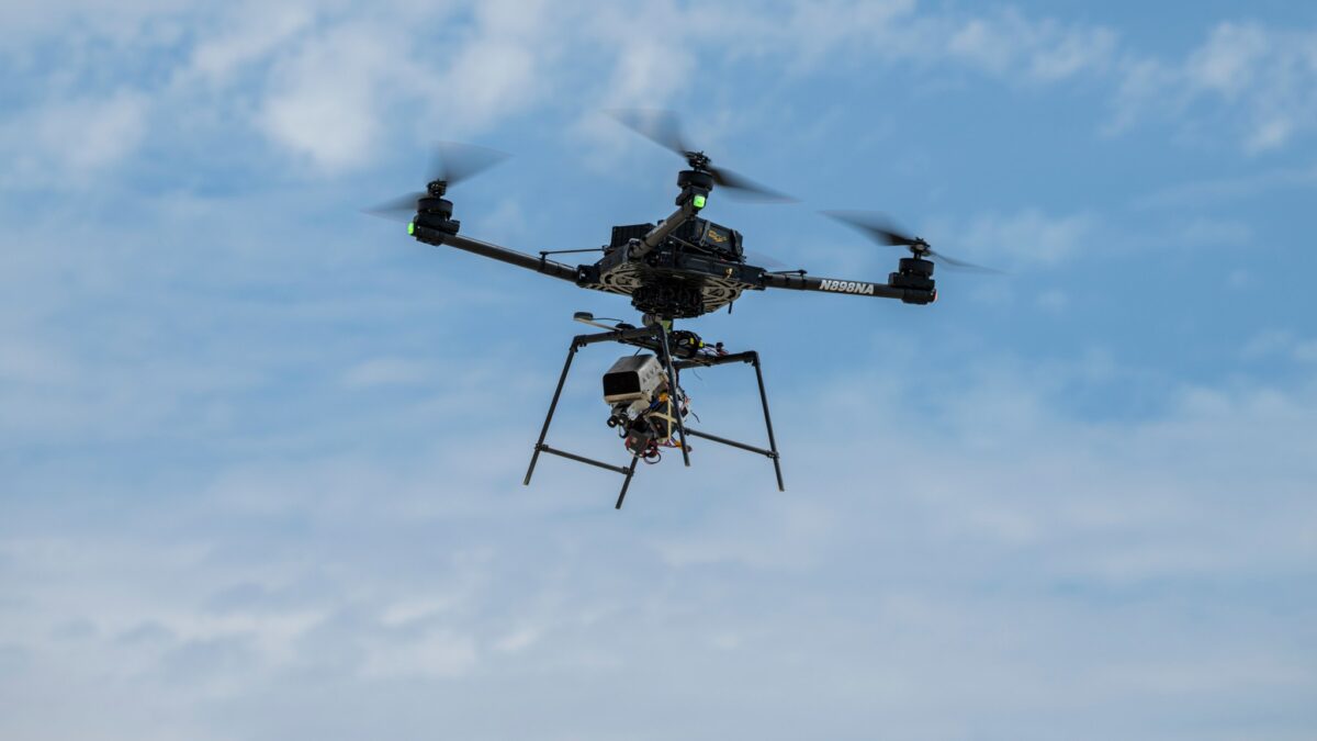 A remotely piloted drone with four rotors carries a guidance and navigation experiment through flight maneuvers.